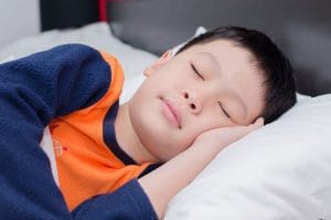 Asian boy sleeping in a bed