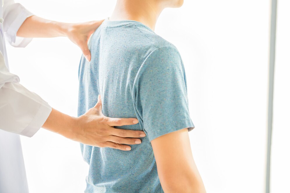 Chiropractor examining a man's upper and lower back during a spine alignment session