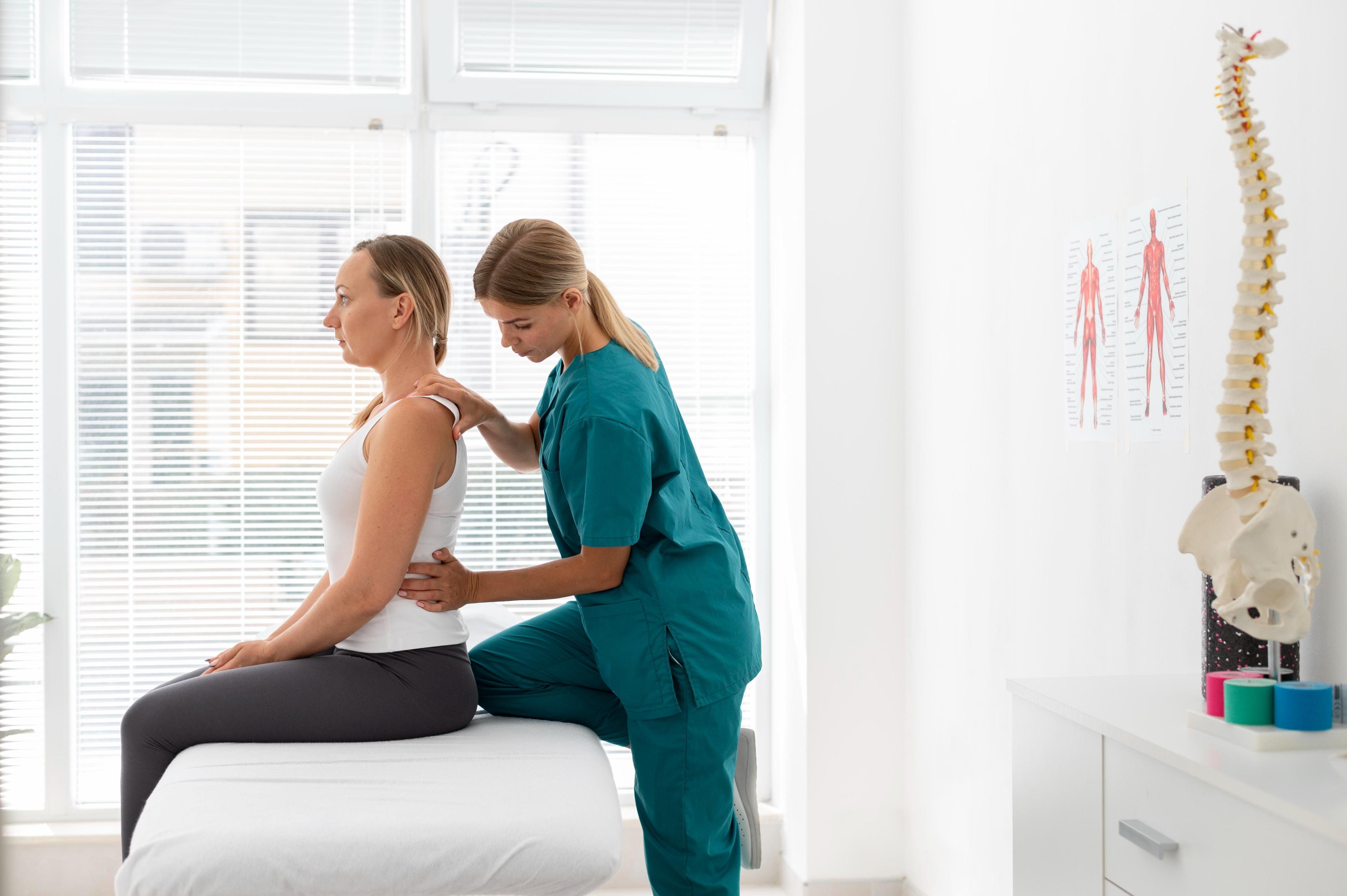 Female chiropractor assessing a woman's spine posture during a chiropractic consultation in a modern clinic
